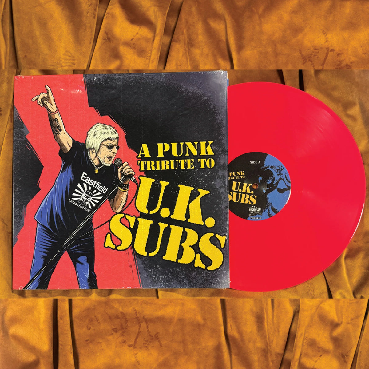 A Punk Tribute to U.K. Subs LP sleeve beside the neon pink vinyl record